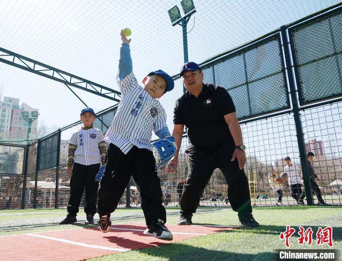 圖為來自臺灣的棒球教練劉興鴻(右)指導(dǎo)小棒球手?jǐn)S球技術(shù)?！●R銘言 攝