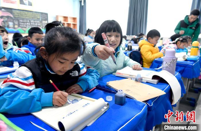 3月14日，西藏拉薩市第一小學(xué)一年級六班學(xué)生白瑪朗珍(圖左)在藏語文課上書寫藏文。　李林 攝