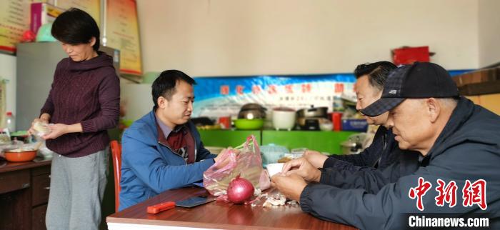 圖為扶貧路上“臨時一家人”準(zhǔn)備午餐。　魏建軍 攝