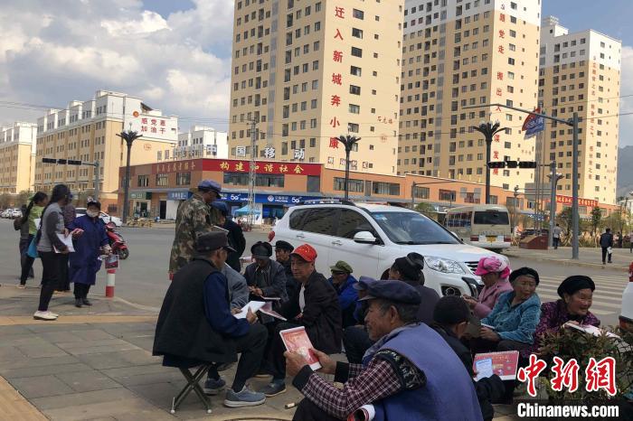 圖為會澤縣城易地扶貧搬遷安置點內(nèi)，老人們聚在廣場上聊天，身后是他們的新家?！】姵?攝