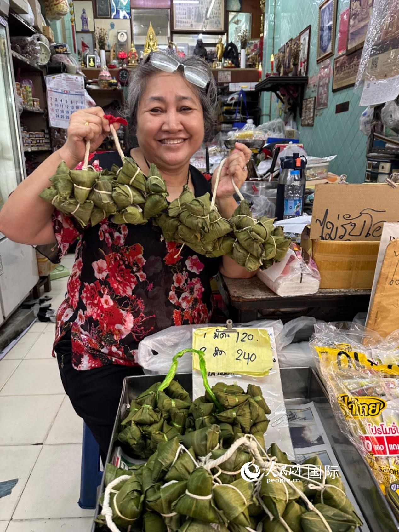 商家向顧客介紹“吉掌”（粽子的一種，一串一串，個頭較?。Ｈ嗣窬W記者 簡承淵攝