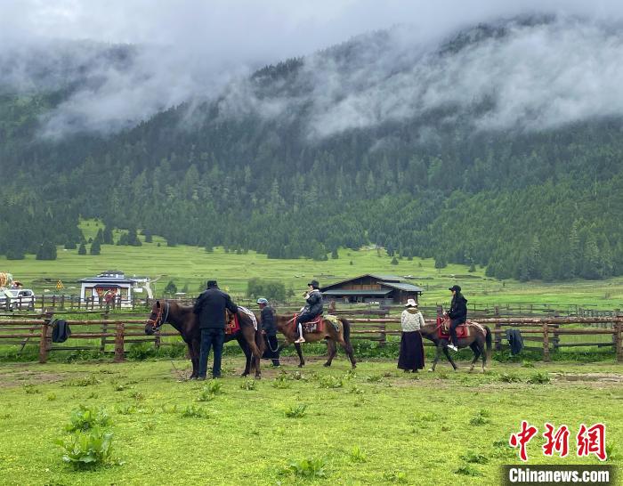 6月10日，游客在魯朗小鎮(zhèn)高山牧場(chǎng)景區(qū)體驗(yàn)騎馬。　冉文娟 攝