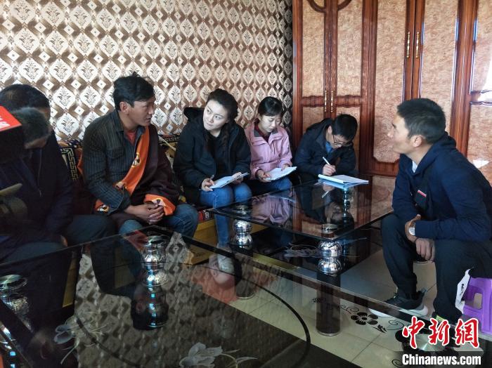 圖為調(diào)查組工作人員正在入戶調(diào)查?！∑钤鲚?攝