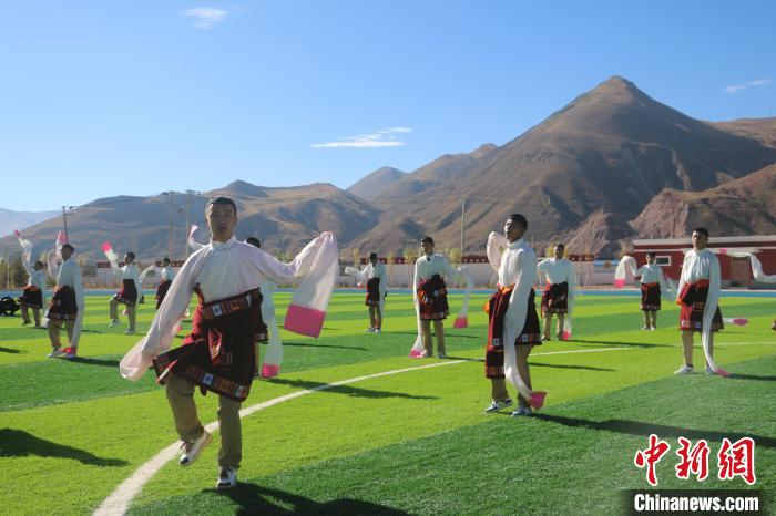 圖為青海師范大學(xué)附屬玉樹(shù)實(shí)驗(yàn)學(xué)校學(xué)生在綠茵場(chǎng)跳起囊謙古舞—卓根瑪?！〕逃?攝