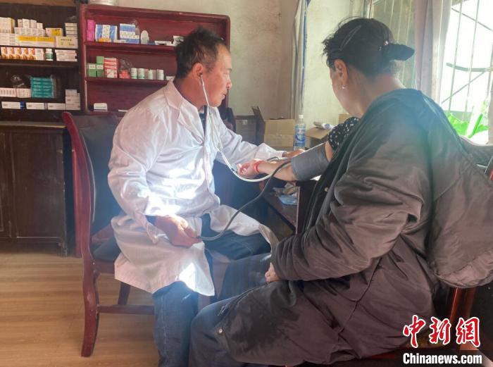 索木滾(左)為村民看病?！∪捞量h委宣傳部供圖