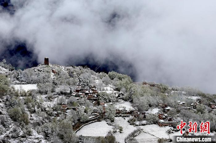 雪后的藏寨和碉樓構(gòu)成美麗的雪景?！〗党鯘衫?攝