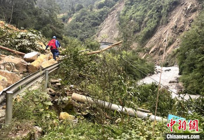電力搶險人員快速通過危險路段，旁邊是受損的電力線路 四川電力供圖