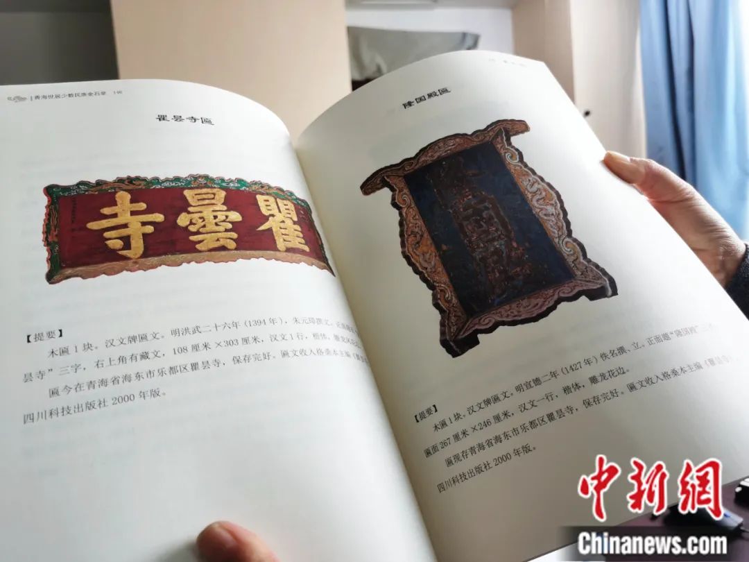 古籍保護(hù)人員展示介紹明代朱元璋撰寫的青海瞿曇寺匾(左)的出版書籍。張?zhí)砀?攝