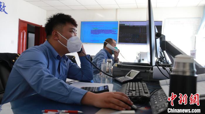 圖為貨運調(diào)度人員與外勤工作人員聯(lián)系掌握車輛裝載情況?！±钌?攝