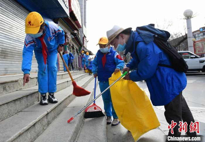 圖為拉薩市小學(xué)生打掃街道?！∝暩聛硭?攝
