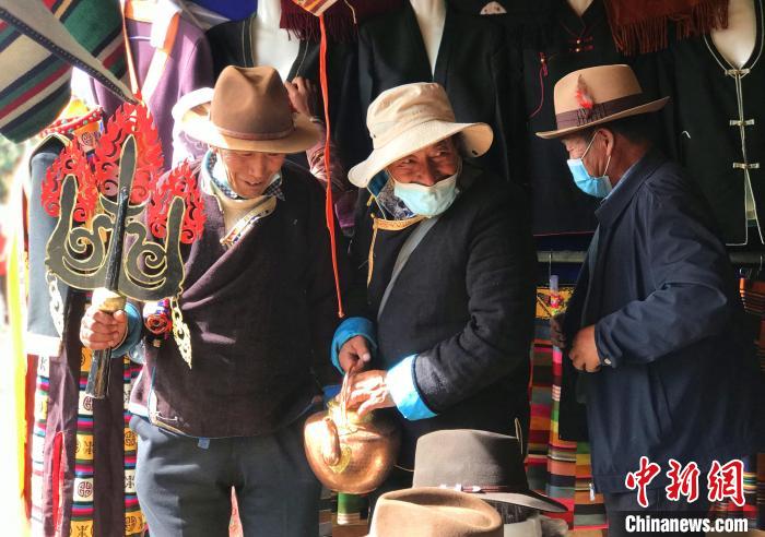 圖為三位藏族老人在集市上聊天交談?！∪轿木?攝