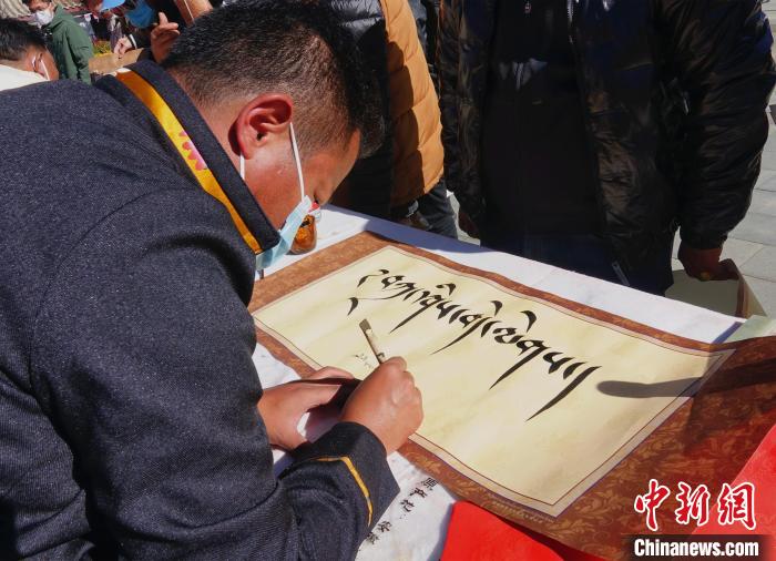 圖為書(shū)法家展示藏文書(shū)法?！∪轿木?攝
