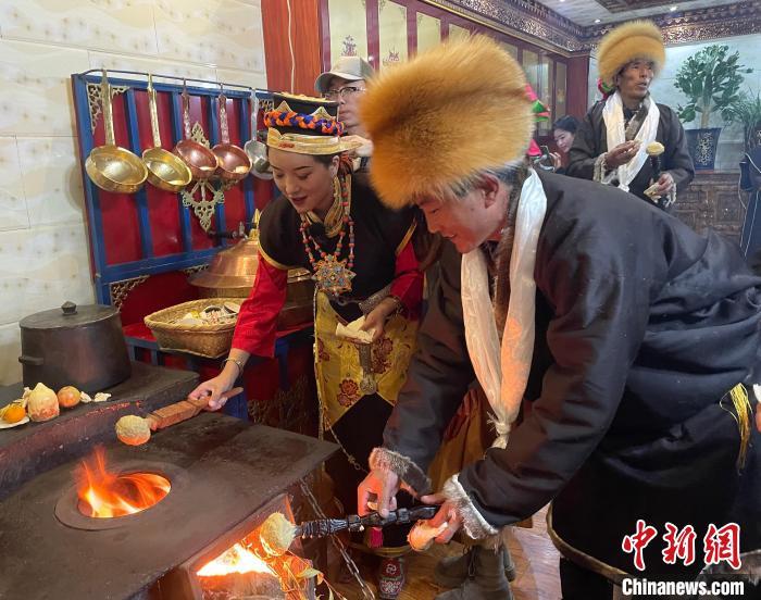 圖為人們?cè)诨鹕峡竟?jié)日美食“結(jié)達(dá)”?！∪轿木?攝