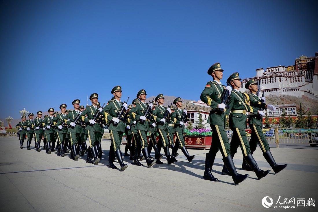 國(guó)旗護(hù)衛(wèi)隊(duì)隊(duì)員緊握鋼槍，踏著威武雄壯的步伐，走向國(guó)旗臺(tái)。人民網(wǎng) 次仁羅布攝