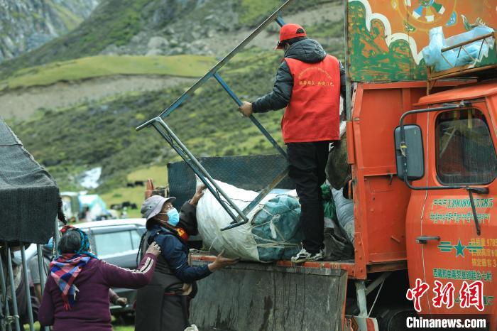 圖為工作人員幫助牧民們卸家具?！÷蹇?攝