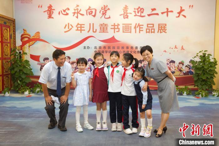 圖為與會嘉賓與入選畫作的“小作者”們在展覽上合影?！≈袊貙W研究中心供圖