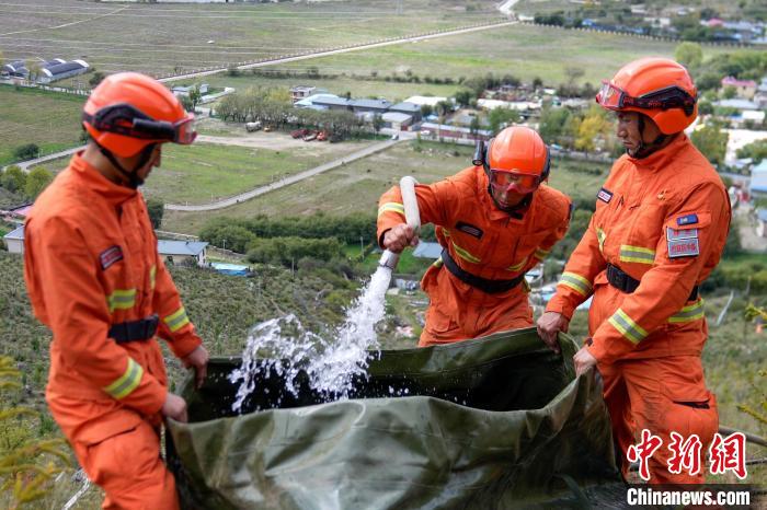 技能大練兵過程中，消防員在陡坡上向蓄水池注水?！±顕鵂c 攝