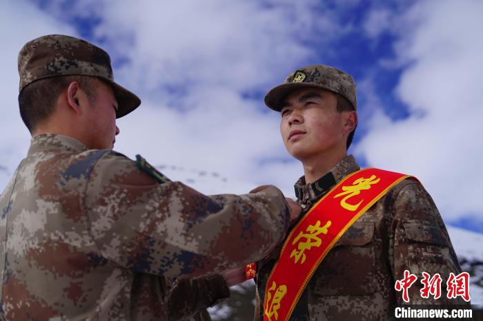排長王朝偉(圖左)給退伍老兵佩戴大紅花?！∥鞑厣侥宪姺謪^(qū)某團供圖