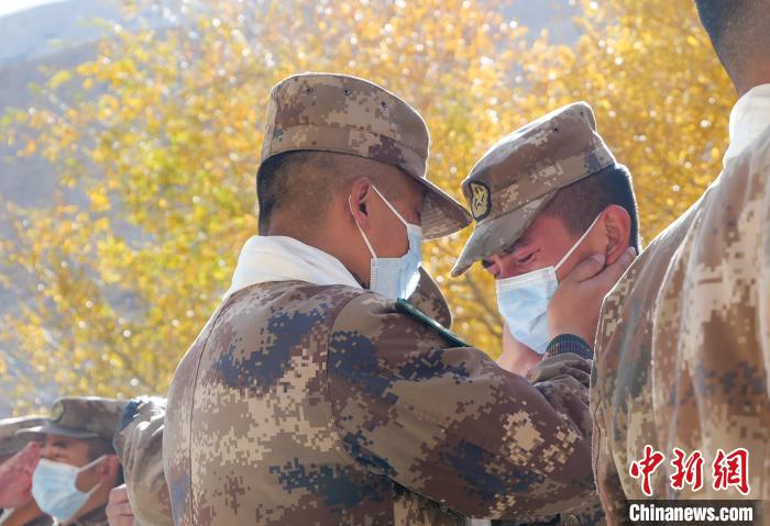 圖為什布奇邊防連退伍老兵與戰(zhàn)友相擁而泣，依依惜別?！⌒觳?攝