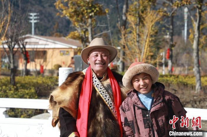 圖為林芝市巴宜區(qū)布久鄉(xiāng)仲果村村民桑杰與孫子一起參加藏歷新年活動?！埩?攝