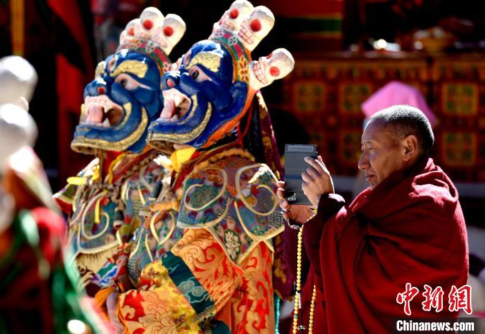 2月19日，正在拍攝跳神活動(dòng)的僧人?！±盍?攝