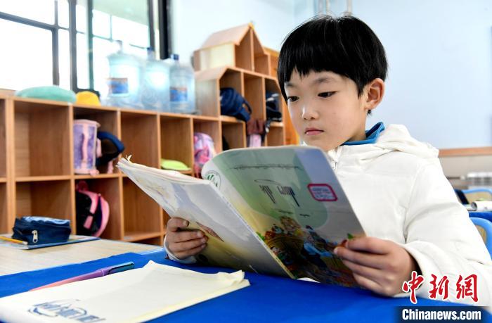 3月14日，西藏拉薩市第一小學(xué)一年級(jí)六班學(xué)生丁增樂吉在閱讀藏語課本。　李林 攝