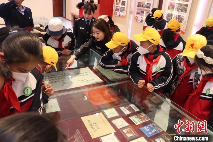 圖為亞東邊檢站民警為駐地小學(xué)生講解該站榮譽發(fā)展史。　胡利媛 攝