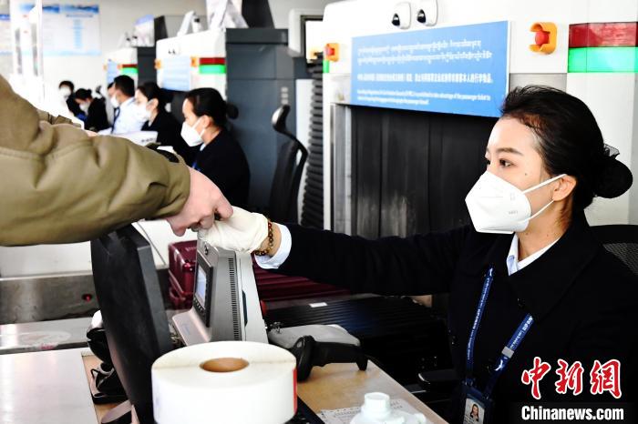 圖為機場工作人員為旅客辦理行李托運?！≈芎?攝