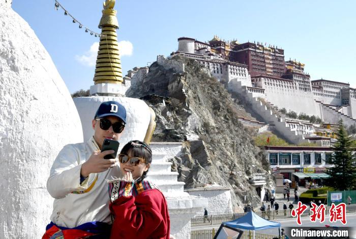 4月17日，游客身著藏式元素服裝在拉薩布達拉宮觀景臺拍照留念?！±盍?攝