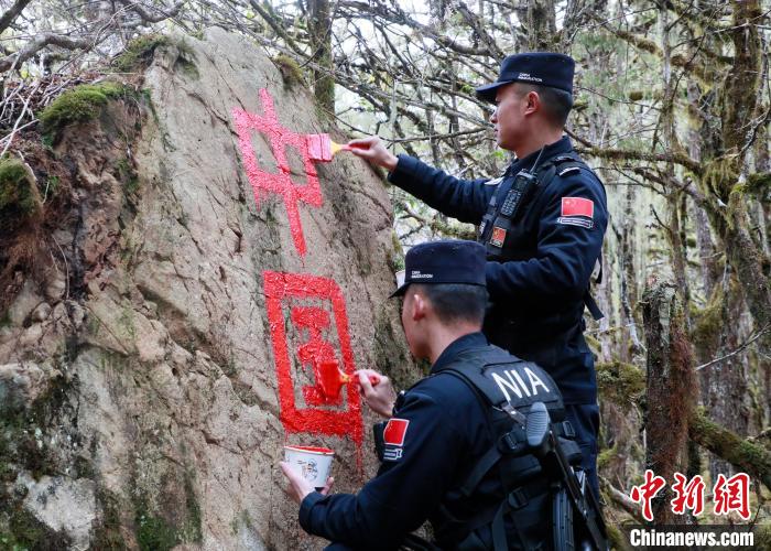 山南邊境管理支隊玉麥邊境派出所民警邊境巡邏途中在石頭上用油漆涂寫“中國”二字 。　鄭琦山 攝