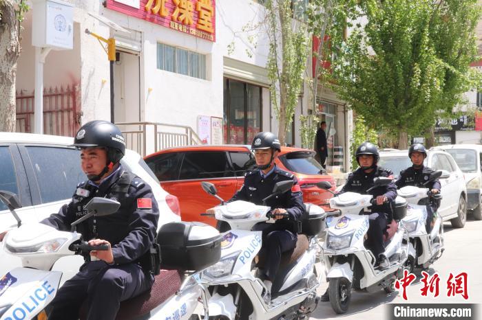 民警騎著電瓶車在轄區(qū)巡邏走訪?！↑S創(chuàng)偉 攝