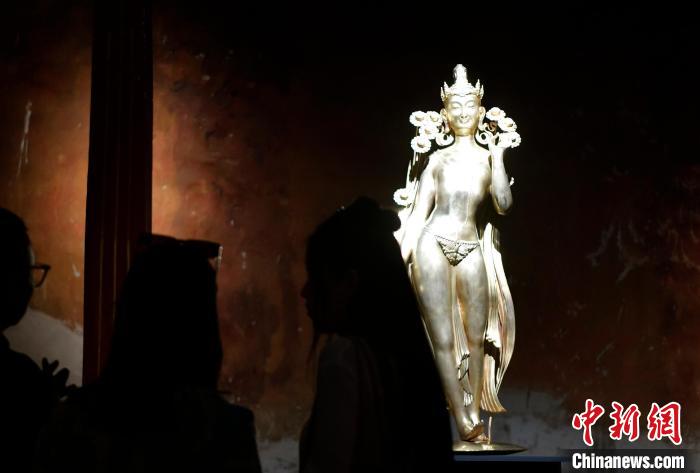 圖為觀眾正在欣賞展覽中的雕塑作品《八萬四千年》?！±盍?攝