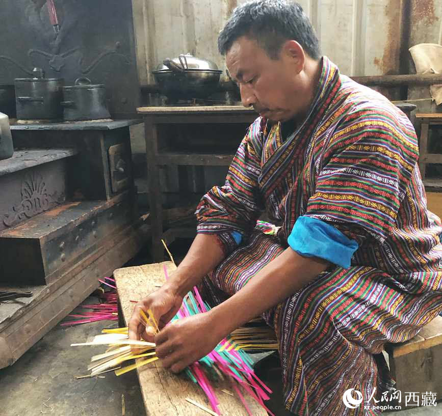 門巴族漢子愛明正在編織藤竹品。