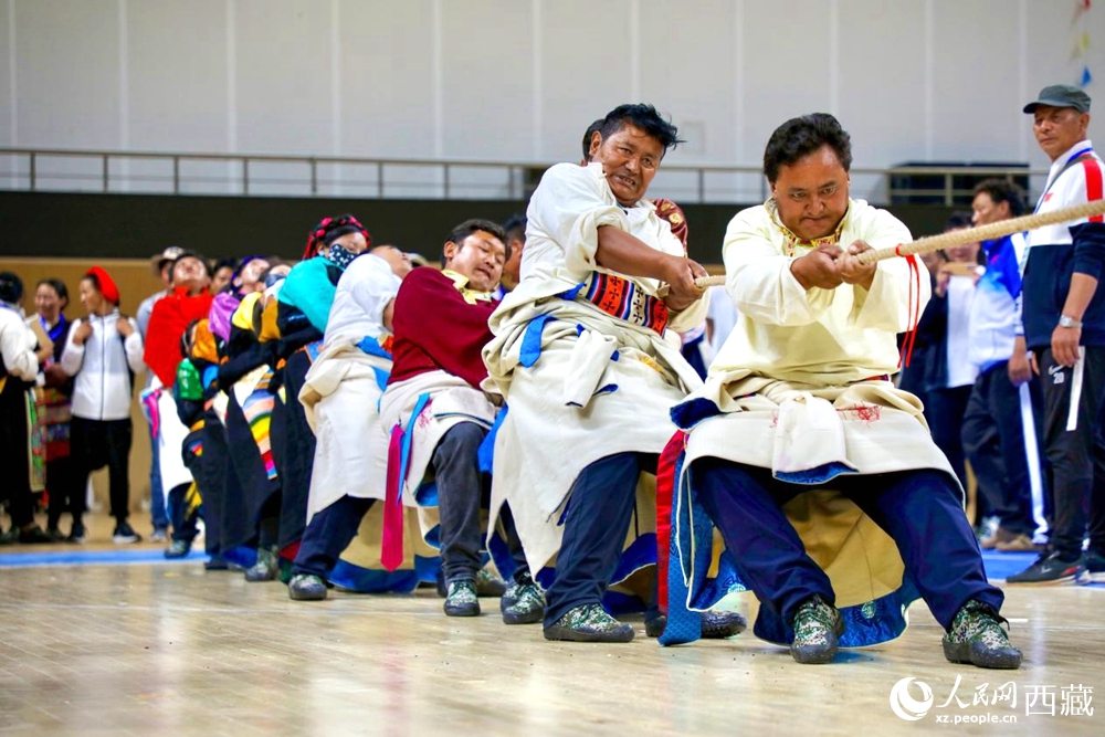 身著民族服裝的農(nóng)牧民選手在拔河比賽現(xiàn)場。