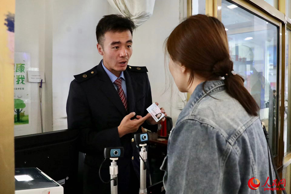 車站工作人員向旅客解答疑問。人民網(wǎng)記者 次仁羅布攝