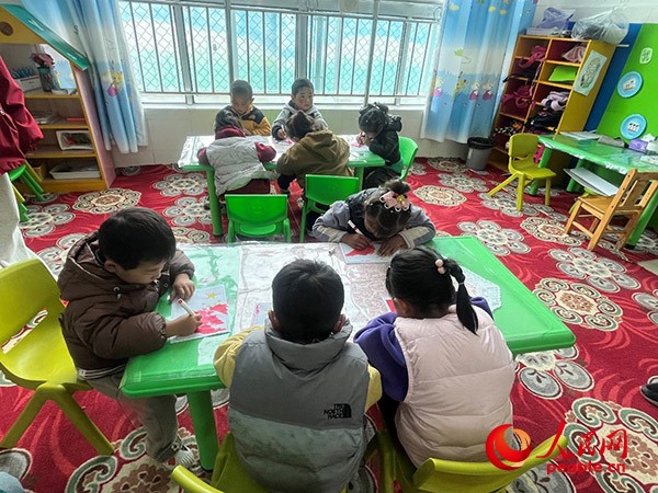拉多村一所現(xiàn)代化幼兒園小班孩子們正在繪畫。張敏穎 攝