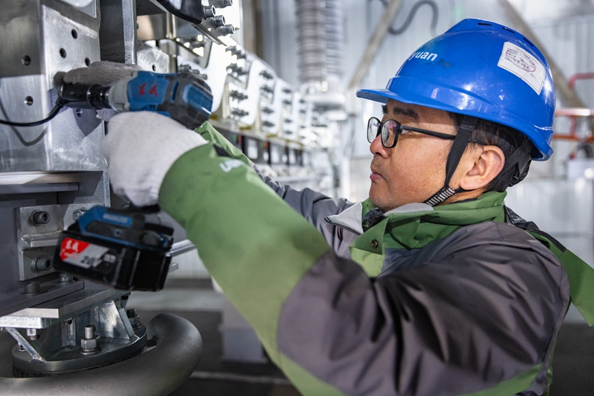 阿里地區(qū)首套電網側帶超容構網型SVG工程現(xiàn)場工作人員正在進行投運前螺栓緊固工作。趙清鵬攝